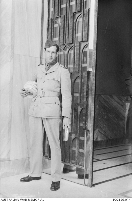 Middle East. c.1941-02. Portrait of Damien Parer standing holding cans of film. Parer was an official Australian war correspondent, photographer and film cameraman with the Department of Information. He served in the Middle East, Greece and the South-West Pacific from 1940 until his resignation in May 1943. He was killed on 17 September 1944 while filming front line operations with the US Marine Corps on Peleliu Island. (Original nitrate negative held in AWM Archive Store)