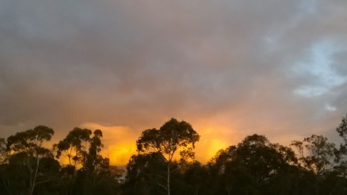 The setting sun, behind me, lighting up the sky.